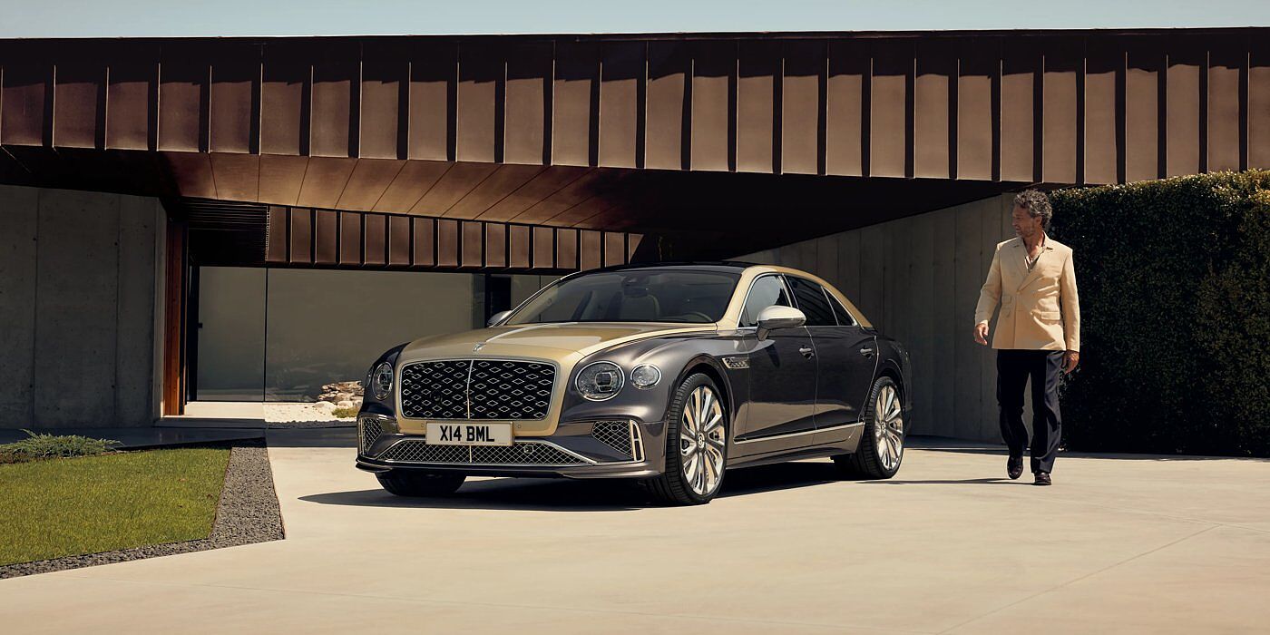 Bentley Cairo Bentley New Flying Spur Mulliner V8 hybrid sedan front three quarters in Rose Gold over Magnetic paint, parked near modern home