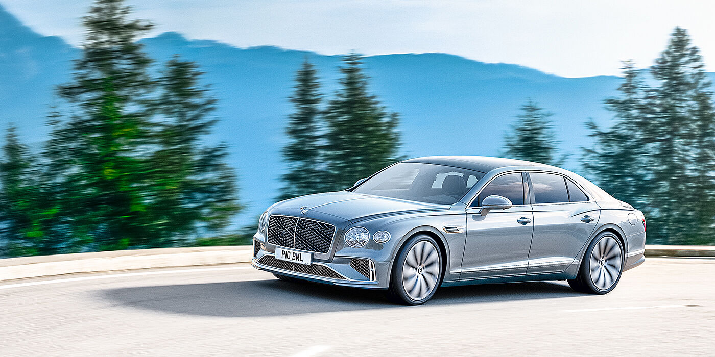 Bentley Cairo New Bentley Flying Spur sedan side view in Silverlake paint with ten spoke wheels and chrome matrix grille driving dynamically on a mountain road